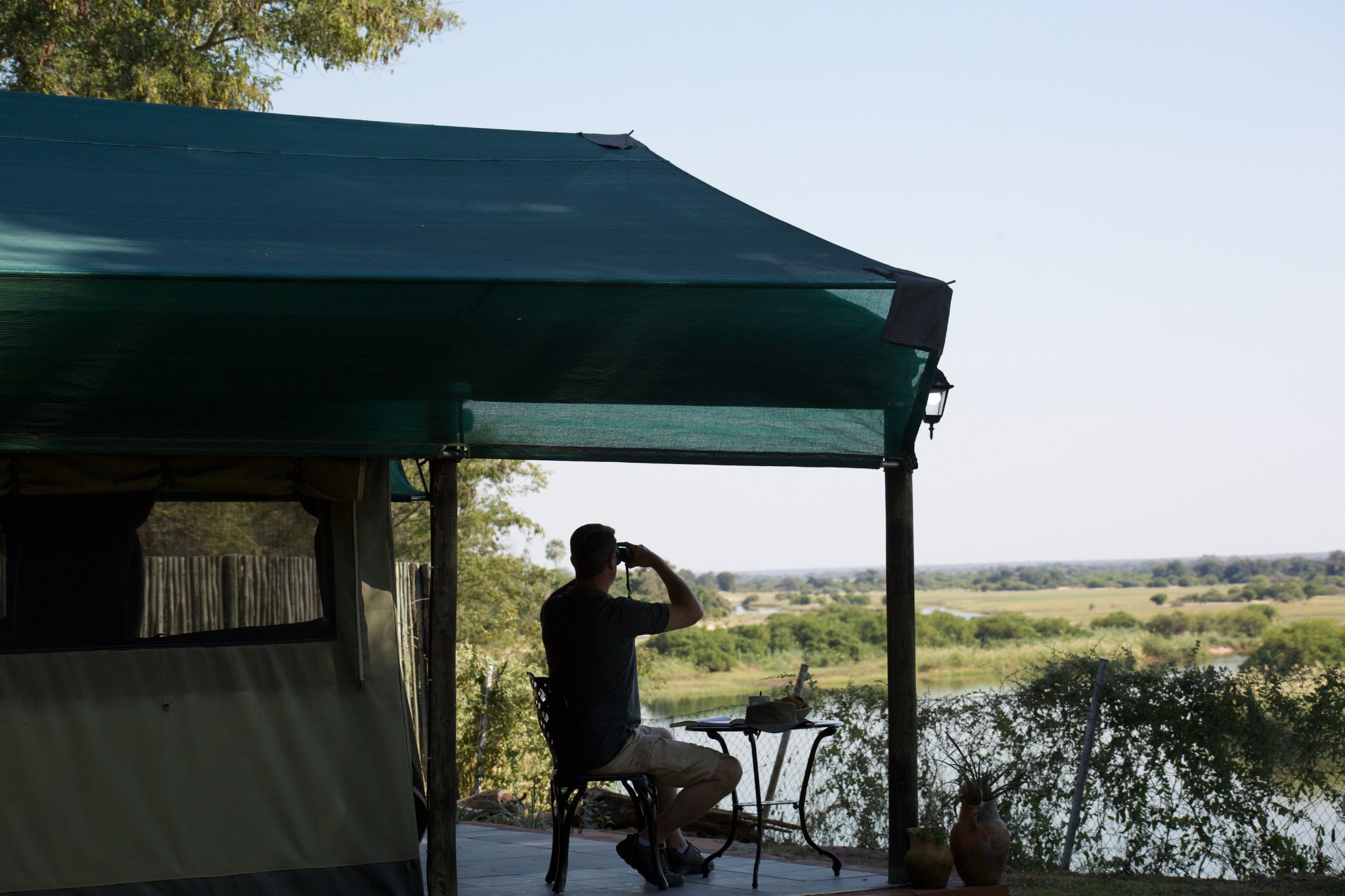 Guest seated on a covered patio overlooking the river